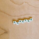 Scrabble tiles spelling 'Happiness' in Cyrillic on a light wooden surface.